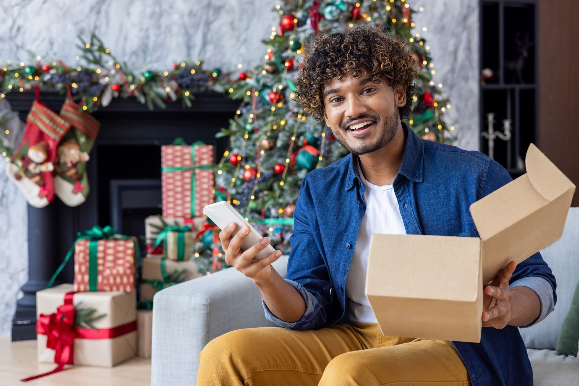 Portrait of a happy buyer in online store, a man smiles and looks at the camera, holds a phone and