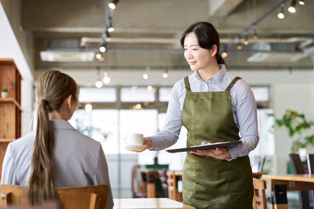 Asian employee carrying snacks at a restaurant